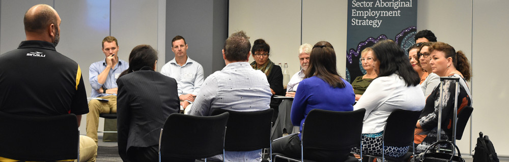 A group sit on chairs in a circle in discussion