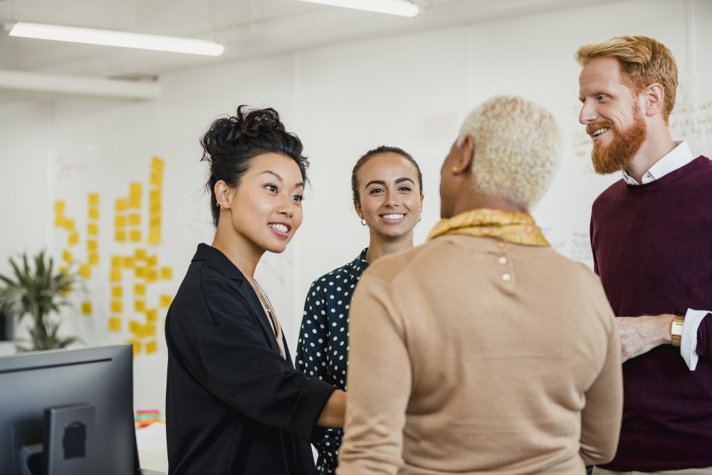 A group of four people standing up having a conversation