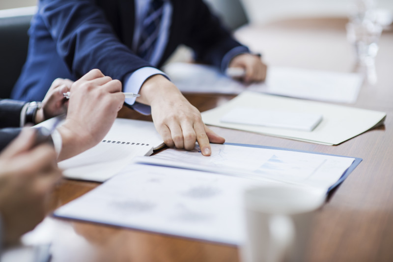 Two people discuss a document on a table in front of them
