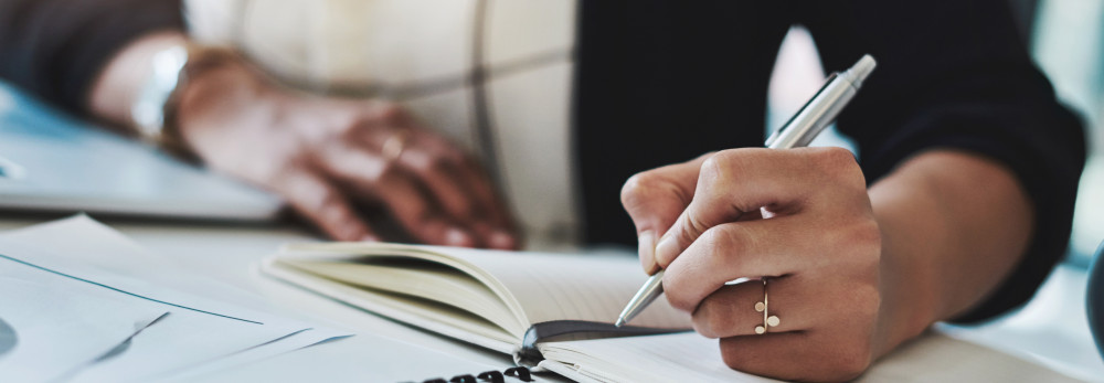 A woman writing on a note pad