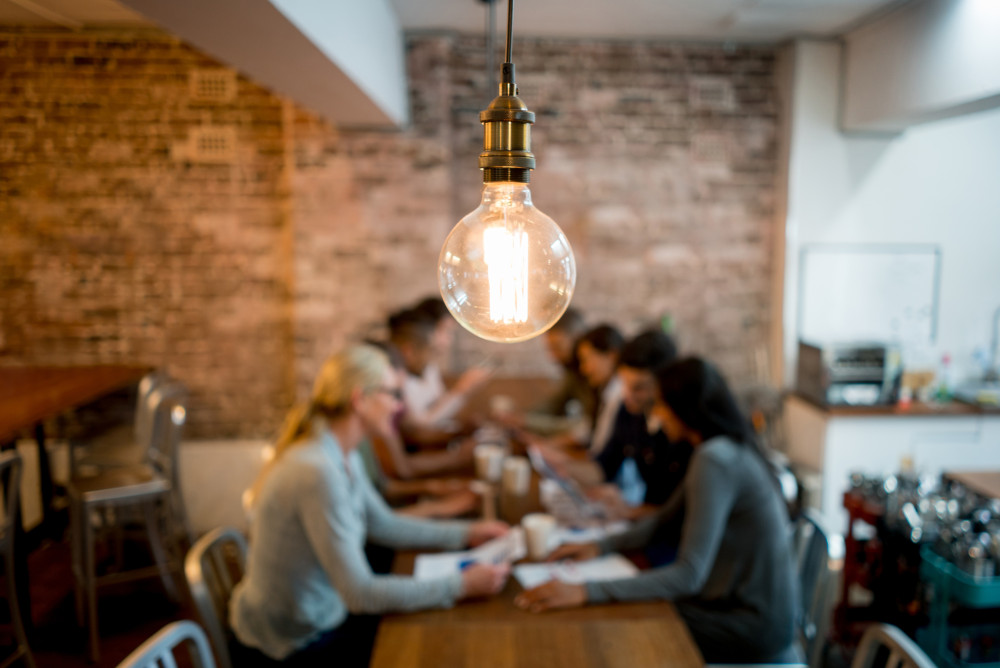 light bulb in front of a team meeting